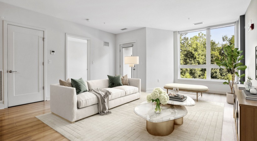 Spacious and well lit living room with wood flooring, large windows and open access to the kitchen Living Room